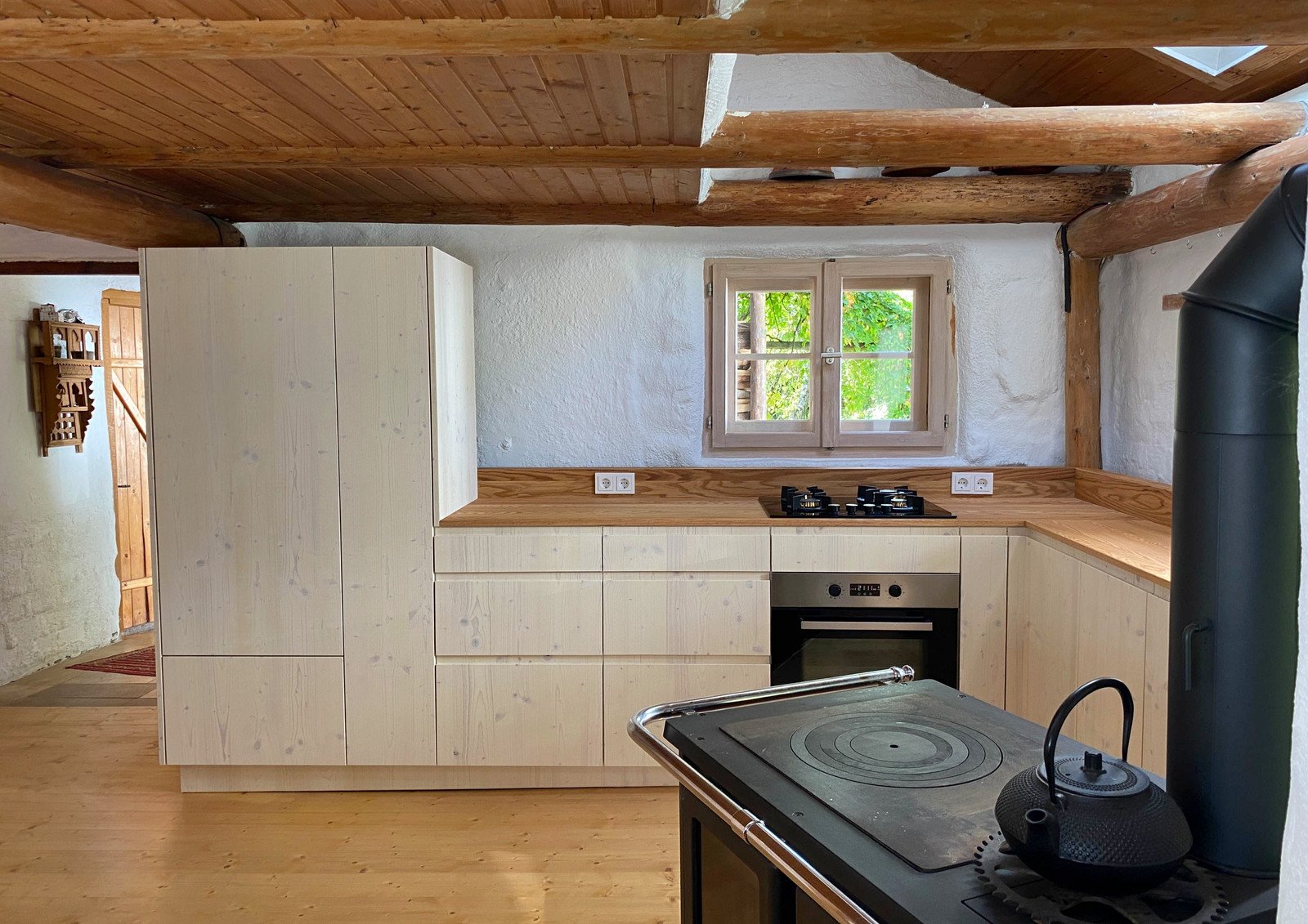 Helle Landhausküche mit Holzbalkendecke, Fichtenfronten und Eichenarbeitsplatte